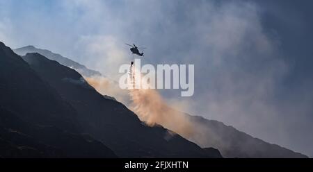 Parc national de Killarney, Irlande - 26 avril. 2021: L'hélicoptère Irish Air Corp déverse de l'eau pour éteindre le feu dans le parc national de Killarney Banque D'Images