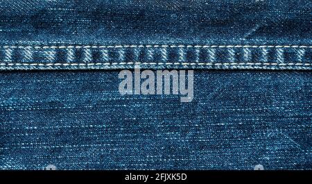 Gros plan des coutures sur un Jean bleu à travers l'écran. Matériau de fond Banque D'Images