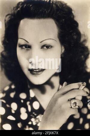 1942 environ , ITALIE : l'actrice italienne LUISA FERIDA ( 1914 - 1945 ) , tuée par des partisans italiens pour sa collaboration avec le fasciste Repubblica di Salò - ATTRICE - Osvaldo Valenti - CINÉMA - TELEFONI BIANCHI - FASCISTA - FASCISMO - R.S.I. - anello - ring - gioielli - gioiello - bijou - bijoux - bijoux - bijoux - bigiotteria - poi - polkadot - polka-dot - sigaretta - cigarette - personalità celebità attori che fumano - fumatrice - fumo - fumée - fumeur - célébrités acteurs personnalité personnalités - ANNI QUARANTA - 40's - main - mano - mani - mains - RESISTENZA - C Banque D'Images