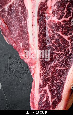 Italian Florentine T bone DRY aged beef Meat Steak Set, sur fond de pierre noire, vue de dessus plat Banque D'Images