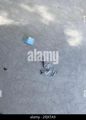 Utilisation d'un masque médical et de gants pour le visage d'un patient coronavirus sur la chaussée du parc, propagation des germes et infection virale nuire aux autres systèmes respiratoires Banque D'Images