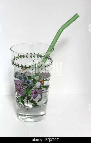 Paille en verre réutilisable colorée dans une tasse en verre transparent. Une alternative pour remplacer la paille à boire en plastique jetable classique, idéale pour l'environnement Banque D'Images