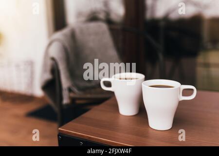 Deux tasses de café sur la table sur la terrasse en bois marron pendant le coucher du soleil avec un fond flou. Détente, silence de la vie de campagne conceep Banque D'Images