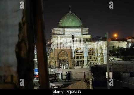 Mossoul, Irak. 26 avril 2021. Une vue de l'intérieur de la fenêtre d'une maison détruite montre la mosquée détruite d'Al-Nuri la nuit. La mosquée Al-Nuri a été construite en 1172 et qui comprend également le minaret Al-Hadba, est actuellement en cours de reconstruction dans son ancienne conception par l'UNESCO après qu'elle ait été détruite pendant la guerre contre l'EI (État islamique d'Irak et de Syrie). Crédit : SOPA Images Limited/Alamy Live News Banque D'Images