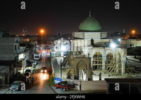 Mossoul, Irak. 26 avril 2021. Une vue depuis le toit d'une maison détruite montre la mosquée détruite d'Al-Nuri la nuit. La mosquée Al-Nuri a été construite en 1172 et qui comprend également le minaret Al-Hadba, est actuellement en cours de reconstruction dans son ancienne conception par l'UNESCO après qu'elle ait été détruite pendant la guerre contre l'EI (État islamique d'Irak et de Syrie). Crédit : SOPA Images Limited/Alamy Live News Banque D'Images