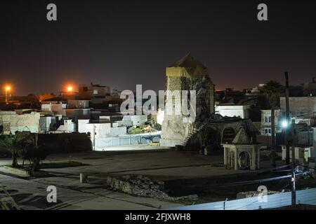 Mossoul, Irak. 26 avril 2021. Une vue depuis le toit d'une maison détruite montre le minaret Al-Hadba détruit la nuit. La mosquée Al-Nuri a été construite en 1172 et qui comprend également le minaret Al-Hadba, est actuellement en cours de reconstruction dans son ancienne conception par l'UNESCO après qu'elle ait été détruite pendant la guerre contre l'EI (État islamique d'Irak et de Syrie). Crédit : SOPA Images Limited/Alamy Live News Banque D'Images