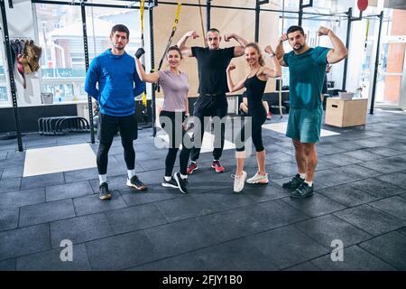 Cinq jeunes sportifs qui font fléchir leurs muscles Banque D'Images