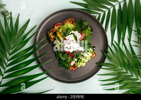 Sandwich à gaufres fraîches avec avocat et œuf poché Banque D'Images