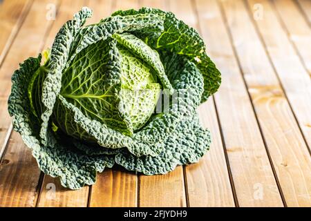 Chou vert de savoie sur table en bois. Banque D'Images