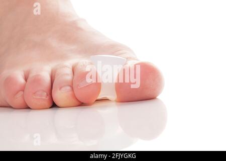 Boignon, hallux valgus. Séparateur de doigt en silicone sur les pieds, isolé sur fond blanc. Banque D'Images