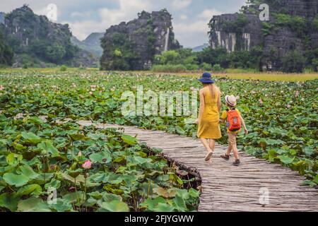 Mère et fils dans un jaune sur le chemin entre le lac de lotus. Grotte MUA, Ninh Binh, Vietnam. Le Vietnam rouvre après la quarantaine Coronovirus COVID 19 Banque D'Images