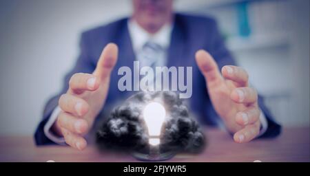 Composition de l'homme d'affaires tenant les mains sur l'ampoule éclairée avec cloud Banque D'Images