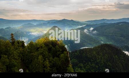 Vue depuis le sommet de Trzy Korony vers l'est Des montagnes de la petite Pieniny au printemps.le rayon de la le coucher du soleil se brise à travers les nuages Banque D'Images