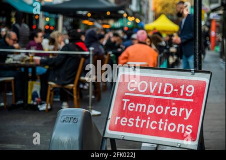 Londres, Royaume-Uni. 26 avril 2021. Certaines personnes aiment boire à l'extérieur malgré le froid - les magasins et les restaurants commencent à ouvrir comme la prochaine étape de l'assouplissement des restrictions de coronavirus, permettant aux magasins non essentiels de rouvrir et aux restaurants/bars de servir les gens à l'extérieur. Crédit : Guy Bell/Alay Live News Banque D'Images