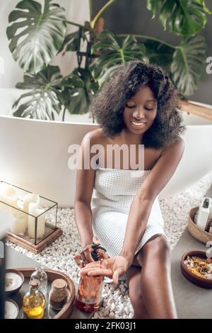 Jeune femme mignon choisir des produits de beauté et se sentir bien Banque D'Images