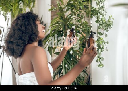 Jeune femme mignon choisir des produits de beauté et se sentir bien Banque D'Images