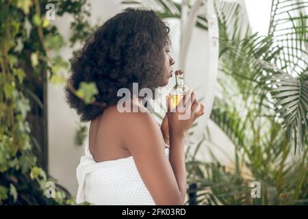 Jeune femme à la peau foncée avec des huiles essentielles à la main Banque D'Images