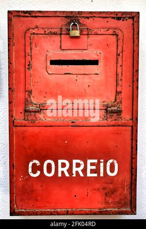 Boîte métallique colorée en rouge sur le mur avec de la vieille peinture à Lisbonne. Mail mot écrit. Banque D'Images