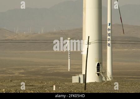 Des éoliennes et des lignes électriques sillonnent le désert à la périphérie ouest de Turpan, dans l'un des endroits les plus chauds de la planète. Les énergies renouvelables éoliennes sont de plus en plus utilisées par les Chinois pour développer leurs industries gourmandes en énergie, comme on le voit ici dans le Xinjiang oriental, en Chine, en RPC. © Time-snapshots Banque D'Images