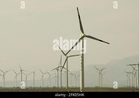 Des éoliennes et des lignes électriques sillonnent le désert à la périphérie ouest de Turpan, dans l'un des endroits les plus chauds de la planète. Les énergies renouvelables éoliennes sont de plus en plus utilisées par les Chinois pour développer leurs industries gourmandes en énergie, comme on le voit ici dans le Xinjiang oriental, en Chine, en RPC. © Time-snapshots Banque D'Images