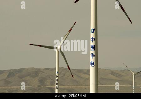 Des éoliennes et des lignes électriques sillonnent le désert à la périphérie ouest de Turpan, dans l'un des endroits les plus chauds de la planète. Les énergies renouvelables éoliennes sont de plus en plus utilisées par les Chinois pour développer leurs industries gourmandes en énergie, comme on le voit ici dans le Xinjiang oriental, en Chine, en RPC. © Time-snapshots Banque D'Images