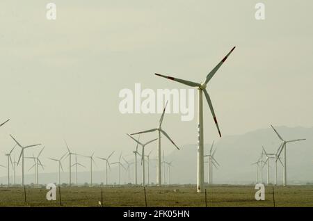 Des éoliennes et des lignes électriques sillonnent le désert à la périphérie ouest de Turpan, dans l'un des endroits les plus chauds de la planète. Les énergies renouvelables éoliennes sont de plus en plus utilisées par les Chinois pour développer leurs industries gourmandes en énergie, comme on le voit ici dans le Xinjiang oriental, en Chine, en RPC. © Time-snapshots Banque D'Images