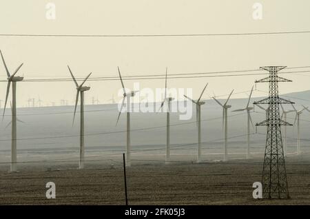 Des éoliennes et des lignes électriques sillonnent le désert à la périphérie ouest de Turpan, dans l'un des endroits les plus chauds de la planète. Les énergies renouvelables éoliennes sont de plus en plus utilisées par les Chinois pour développer leurs industries gourmandes en énergie, comme on le voit ici dans le Xinjiang oriental, en Chine, en RPC. © Time-snapshots Banque D'Images