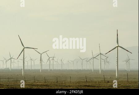 Des éoliennes et des lignes électriques sillonnent le désert à la périphérie ouest de Turpan, dans l'un des endroits les plus chauds de la planète. Les énergies renouvelables éoliennes sont de plus en plus utilisées par les Chinois pour développer leurs industries gourmandes en énergie, comme on le voit ici dans le Xinjiang oriental, en Chine, en RPC. © Time-snapshots Banque D'Images