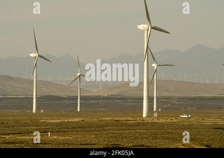 Des éoliennes et des lignes électriques sillonnent le désert à la périphérie ouest de Turpan, dans l'un des endroits les plus chauds de la planète. Les énergies renouvelables éoliennes sont de plus en plus utilisées par les Chinois pour développer leurs industries gourmandes en énergie, comme on le voit ici dans le Xinjiang oriental, en Chine, en RPC. © Time-snapshots Banque D'Images