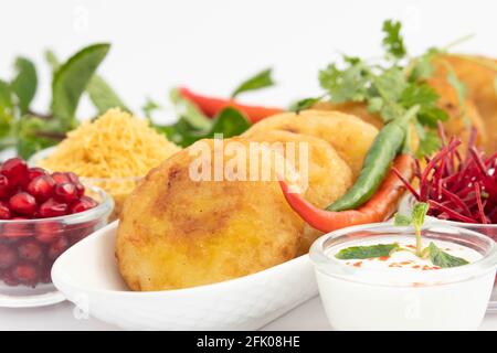 Célèbre Indian Street Food snacks Aloo Tikki également connu sous le nom Alu Ki Tikkia est une purée de pommes de terre cuite assaisonnée ou Viandes servies avec Dahi Chat Masal Banque D'Images