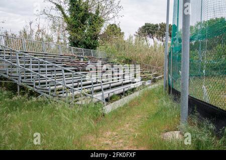 Des gradins abandonnés devant un terrain de baseball en Toscane Italie Banque D'Images