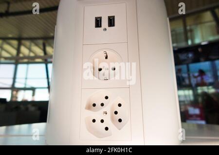 Ensemble de prises de charge électrique ( prise usb inc ) pour charger les batteries électriques dans les appareils mobiles des passagers / passagers. Aéroport de Genève Cointrin, Suisse. Banque D'Images