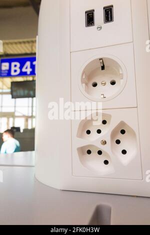 Ensemble de prises de charge électrique ( prise usb inc ) pour charger les batteries électriques dans les appareils mobiles des passagers / passagers. Aéroport de Genève Cointrin, Suisse. Banque D'Images