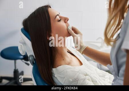Employé de cabinet dentaire prenant l'impression de dents de la bouche de dame Banque D'Images