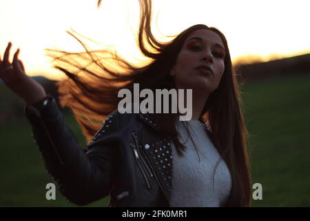 Portrait d'une jeune femme hispanique au maquillage posant dans le champ au coucher du soleil Banque D'Images