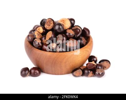 Graines de guarana dans un bol en bois, isolées sur fond blanc. Supplément alimentaire guarana, source de caféine pour boissons énergétiques. Banque D'Images