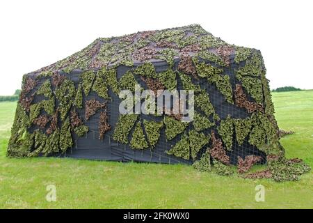 Une grande tente militaire avec une couverture de camouflage. Banque D'Images