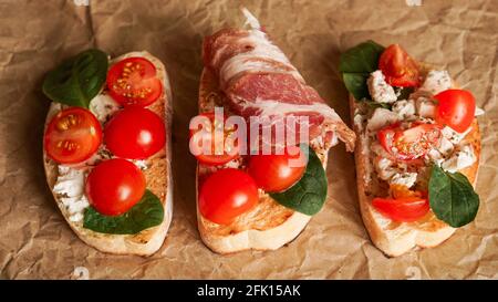 Trois bruschetta fraîches sur papier artisanal. Délicieux en-cas. Vue de dessus Banque D'Images