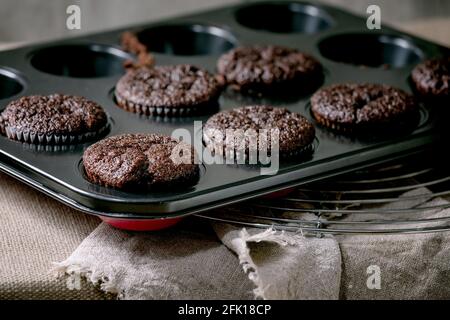 Petits gâteaux au chocolat maison frais sous forme de muffins pour cuisiner sur une table de cuisine avec nappe. Boulangerie maison Banque D'Images