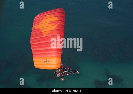 Prise de vue en grand angle du parapente motorisé volant au-dessus du océan Banque D'Images