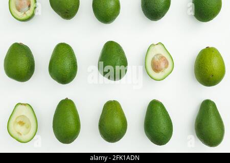 Motif d'avocat entier et demi sur fond blanc. Flat lay, vue de dessus. Concept alimentaire. Banque D'Images