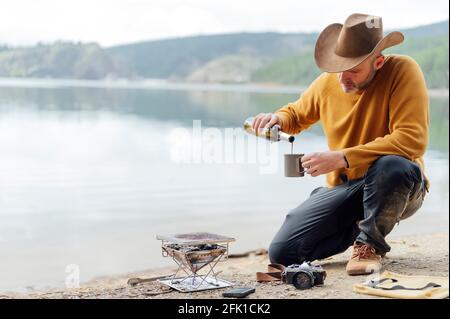 Homme préparant un barbecue sur brazier dans la nature Banque D'Images