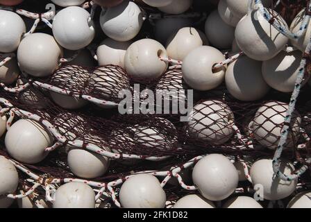 Un gros plan plein cadre de flotteurs blancs emmêlés dans des cordes et un filet de pêche couleur marron. Photographié sur un bateau dans un port grec. Banque D'Images