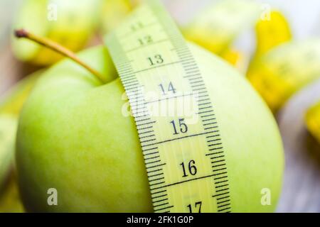 Ruban de mesure jaune couché sur UNE pomme verte - la vie Concept sain Banque D'Images