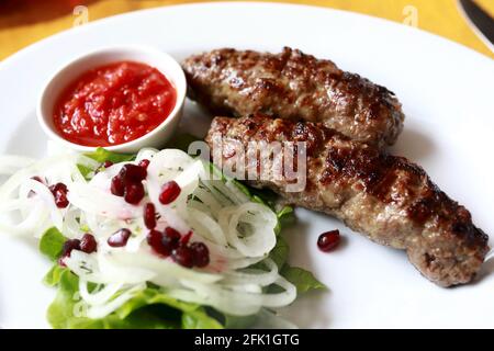 Veau lula kebab avec oignons sur la plaque blanche dans le restaurant Banque D'Images