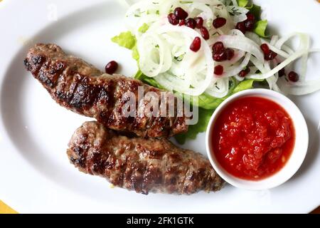 Veau lula kebab avec oignons et sauce sur l'assiette restaurant Banque D'Images
