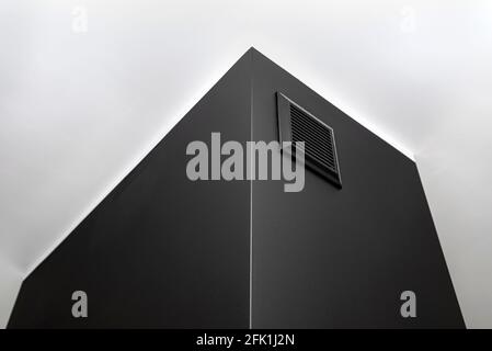 Une grille de ventilation dans une cheminée moderne avec une chambre de combustion fermée dans le salon en noir. Banque D'Images