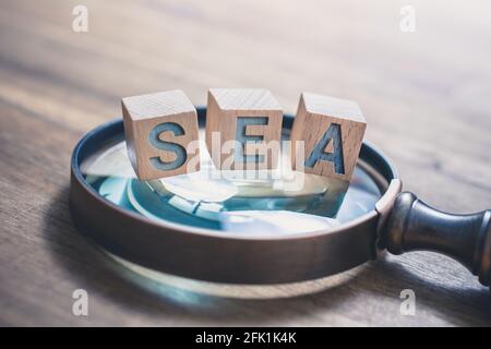 Loupe d'époque avec BLOCS DE MER sur une ancienne table en bois - concept de publicité de Search Engine Banque D'Images