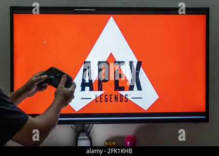 Homme tenant le régulateur de vapeur devant un écran de chargement apex legends un jeu de tir multijoueur massivement en ligne avec des millions de joueurs de suiveurs Banque D'Images