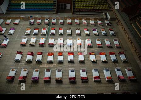 Srinagar, Inde. 27 avril 2021. Des rangées de lits sont placées à l'intérieur d'un stade sportif intérieur transformé en centre d'isolement COVID-19 à Srinagar. Le Jammu-et-Cachemire a signalé 3,164 cas positifs, le plus élevé depuis le déclenchement de la pandémie Covid-19 l'année dernière, faisant passer le nombre de cas actifs à 22,283, qui étaient autrement moins de 600 environ un mois auparavant. Une femme de 20 ans a été signalée parmi les vingt-cinq décès survenus dans J&K au cours des 24 dernières heures, portant le nombre de décès à 2,197. Crédit : SOPA Images Limited/Alamy Live News Banque D'Images